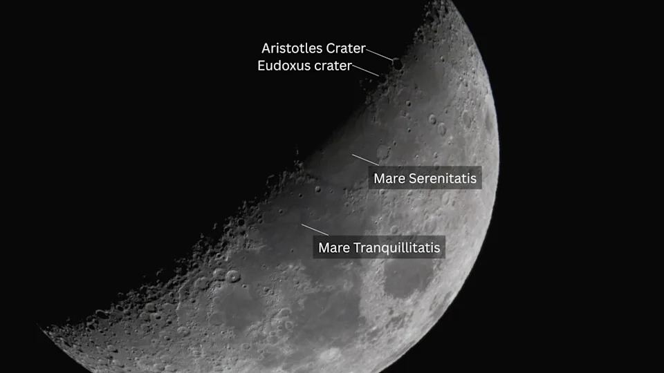 صورة للقمر ونصفه الأيمن مضاء بسماء سوداء، مع ملصقات توضح مواقع البحار القمرية والحفر البارزة.