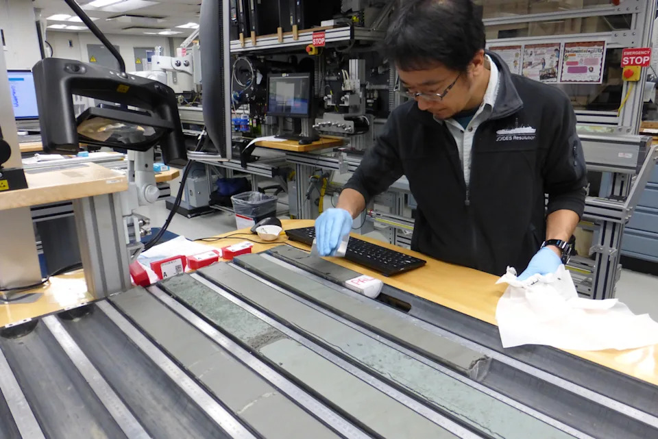 ينظر الشخص إلى شرائح رمادية طويلة من الصخور.