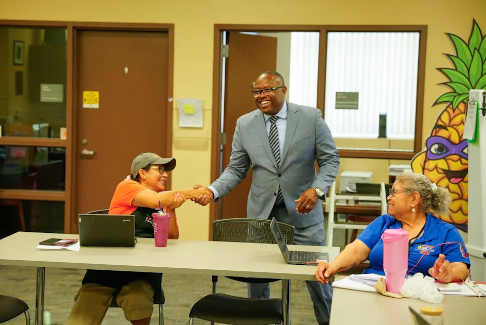 مدير منطقة مدارس نيو بالم سبرينغز الموحدة، الدكتور ماركوس فونشيس، يرحب بموظفي خدمات التغذية غابرييلا روشا، على اليمين، وماريا رييس في أول يوم له في العمل في 1 يوليو 2025، في بالم سبرينغز.