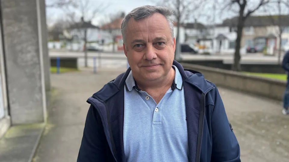 رجل أوكراني يرتدي سترة زرقاء يبتسم للكاميرا 