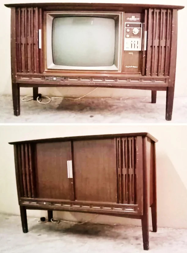 وحدة تلفزيون خشبية عتيقة مع شاشة مستديرة في الأعلى وأبواب منزلقة في الأسفل لإخفاء مساحة التخزين