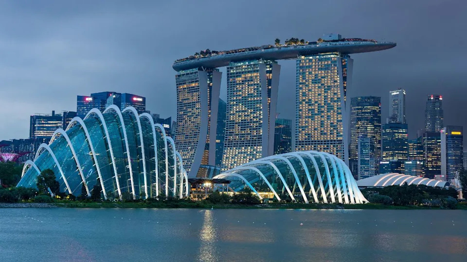 سنغافورة - 22 نوفمبر 2023: مارينا باي ساندز الشهيرة ومباني الواجهة البحرية الأخرى في وسط مدينة سنغافورة أثناء غروب الشمس العاصف