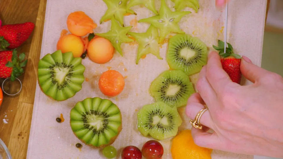 تيجان وشرائح الكيوي، فاكهة النجمة، العنب، البابايا والفراولة.