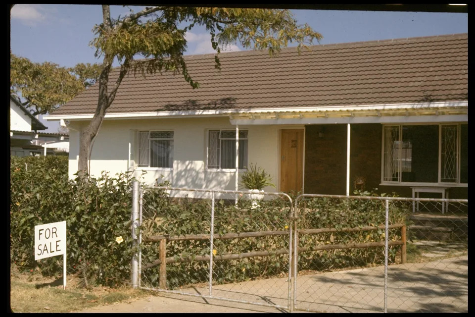 منزل من طابق واحد مع ساحة مسيجة و "للبيع" تسجيل الدخول في الأمام، يقع في شارع هادئ