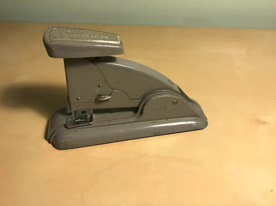 دباسة معدنية قديمة موضوعة على سطح عادي