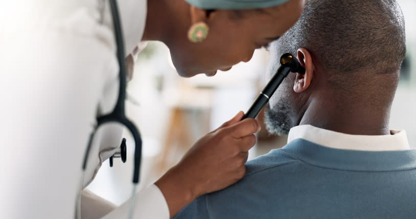 يقوم أخصائي الرعاية الصحية بفحص أذن المريض باستخدام منظار الأذن في بيئة طبية