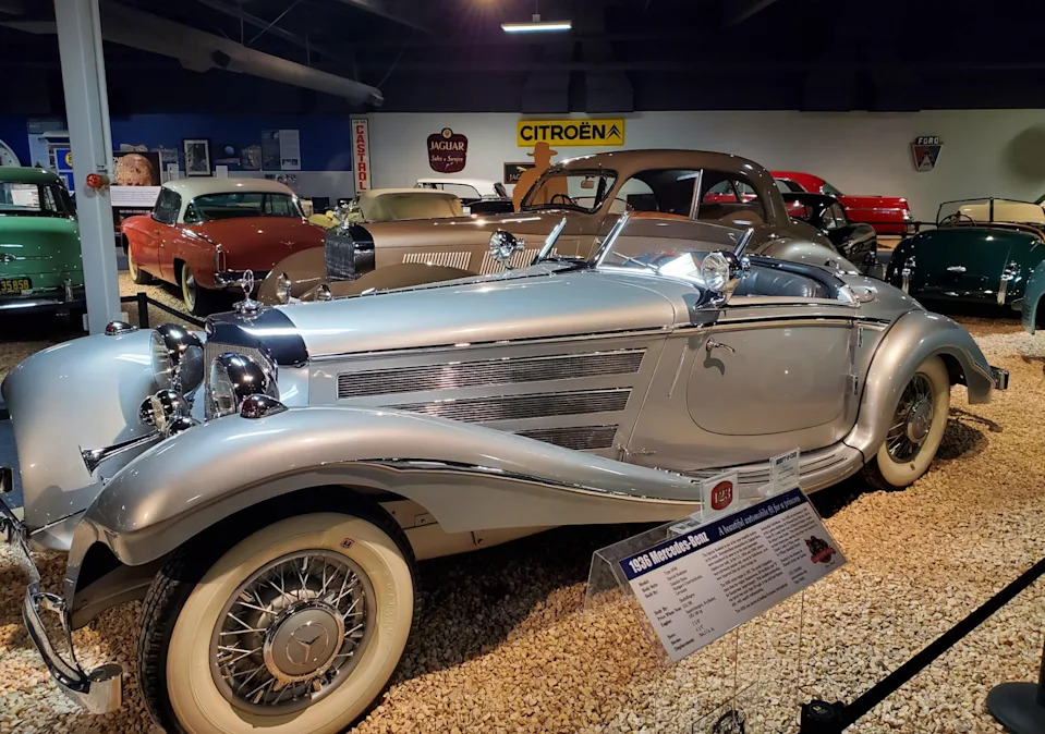 سيارة مرسيدس بنز قديمة معروضة في المتحف مع سيارات كلاسيكية أخرى في الخلفية