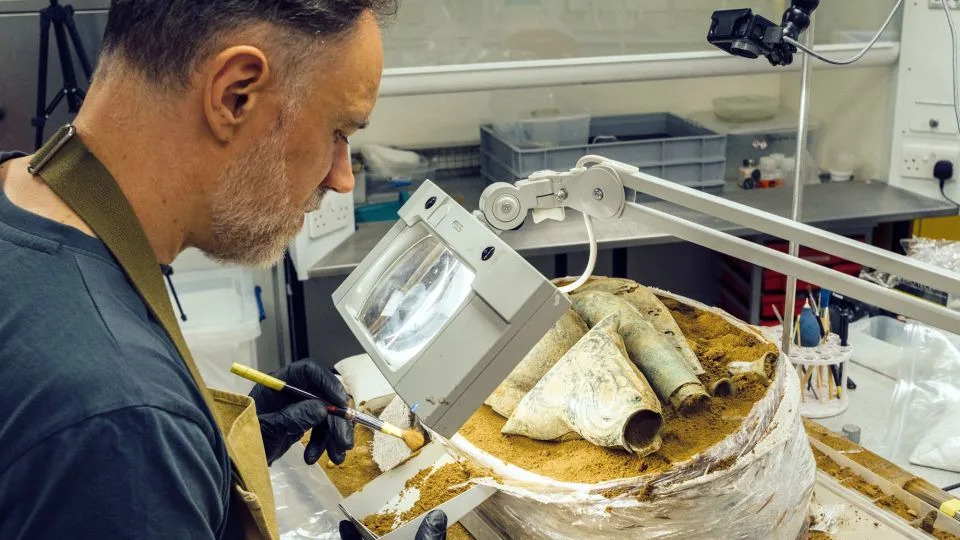 يجري جوناثان كلارك، أحد كبار المرممين في خدمة متاحف نورفولك، عملية تنقيب دقيقة عن الكنز. - خدمة متاحف نورفولك/إنجلترا التاريخية