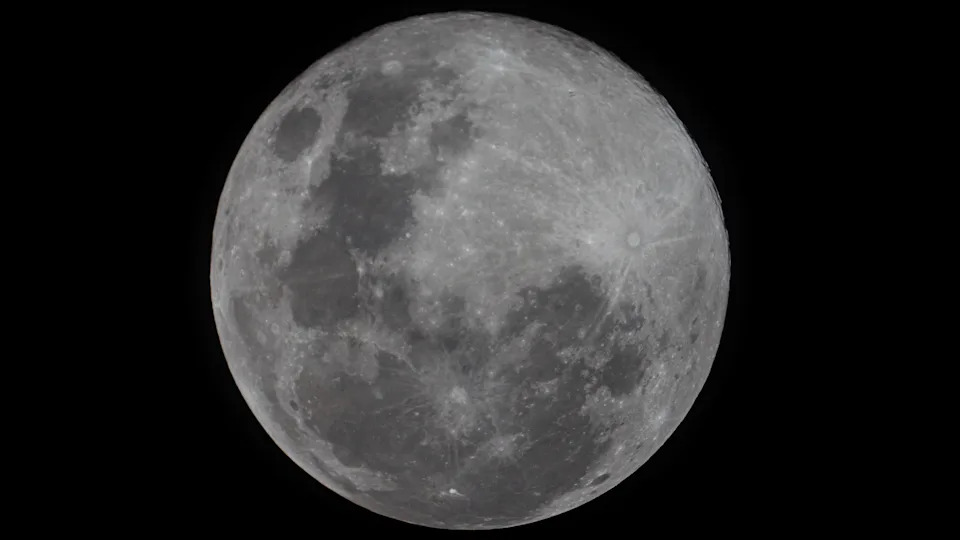 صورة تفصيلية لقمر مكتمل يسطع في سماء الليل السوداء.