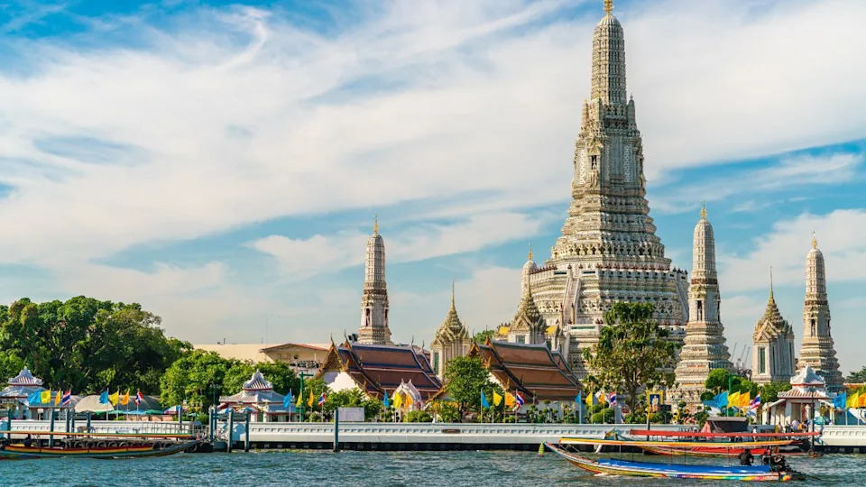 قارب السفر في خلفية نهر تشاو فرا يا مع مشاهدة معالم معبد الفجر في بانكوك بتايلاند