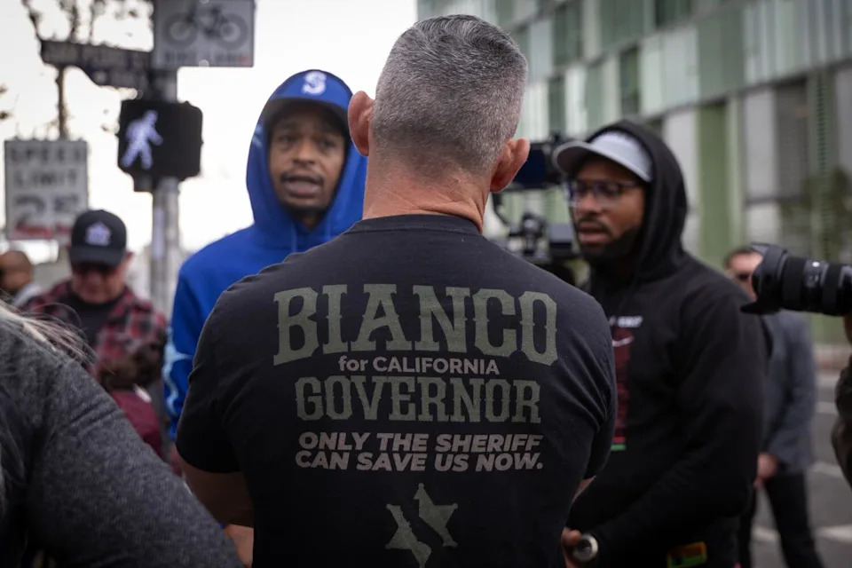 الجزء الخلفي من رجل يتحدث إلى رجلين.