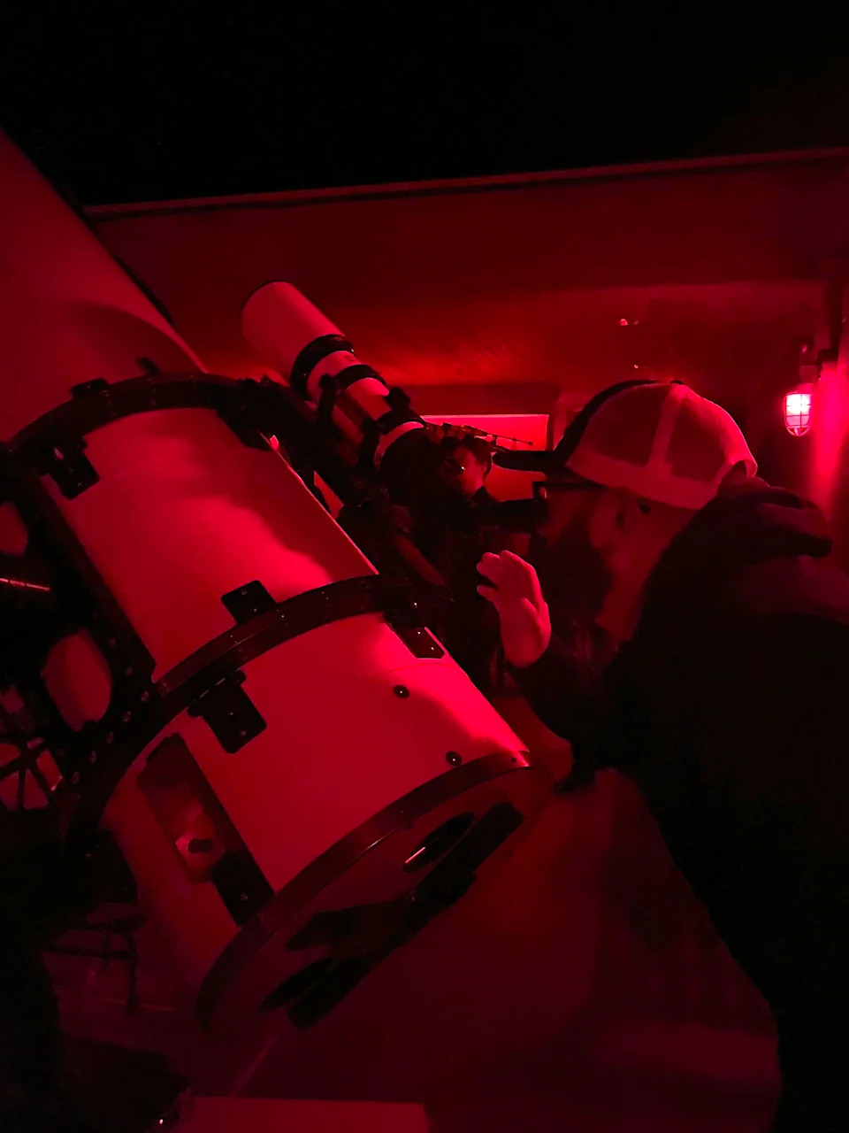 رجل يرتدي قبعة وينظر من خلال التلسكوب