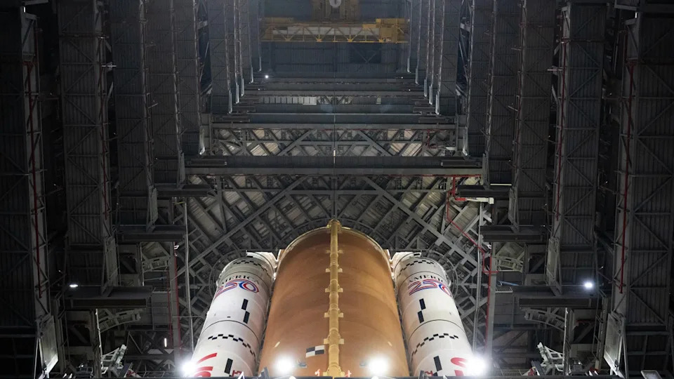 يضيء صاروخ كبير وينظر إلى مستودع كبير.