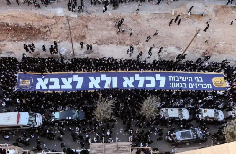 اليهود المتدينون يحملون لافتة باللغة العبرية كتب عليها “إلى السجن وليس الجيش”، خلال احتجاج “مليون رجل” ضد التجنيد العسكري، في القدس، 30 أكتوبر، 2025. (الائتمان: أم كادوش / رويترز)